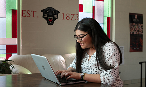 Female Drury student working on laptop