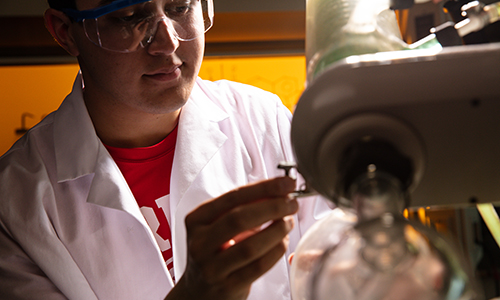 Student examining microscope.