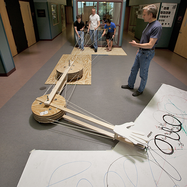 Physics students working on robotic arm.