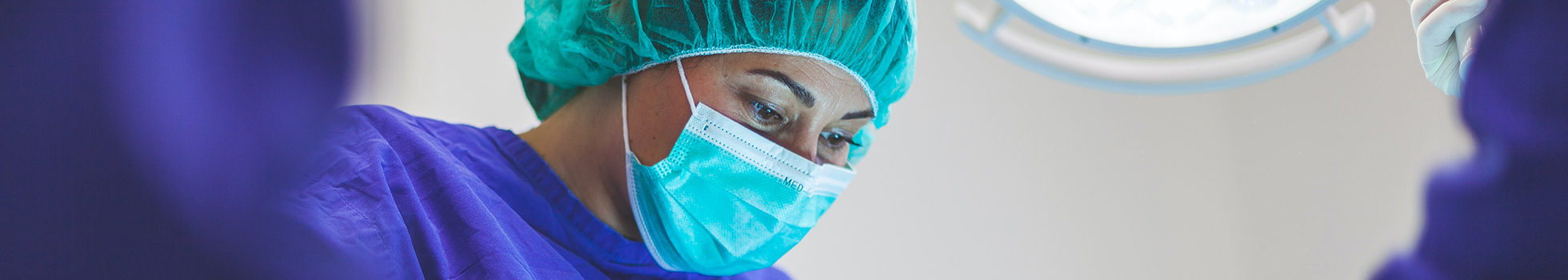 Woman in scrubs and mask.