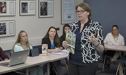 A women presenting to a room of people.