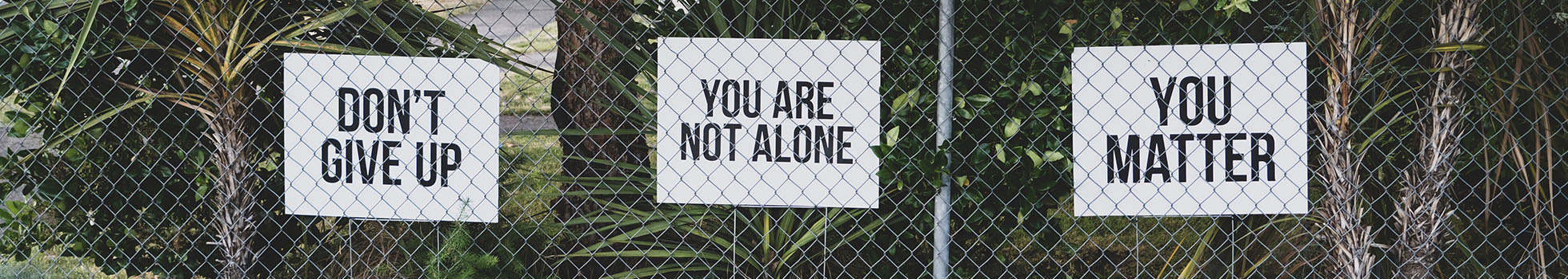 Fence with signs saying don't give up, you matter, and you are not alone.