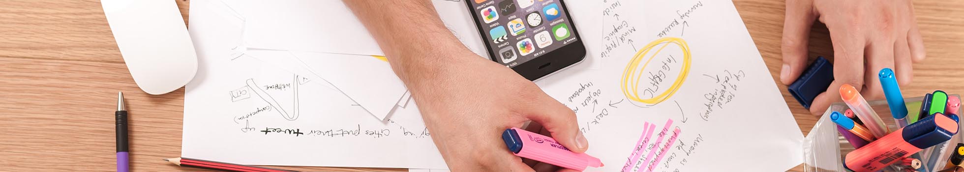 Man writing on paper with a highlighter.