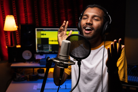 A male student singing in a studio.