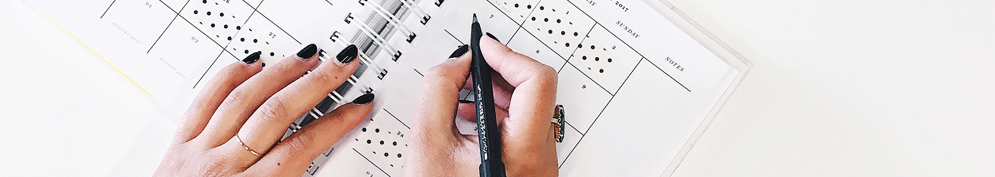 Woman writing a schedule on a calendar.