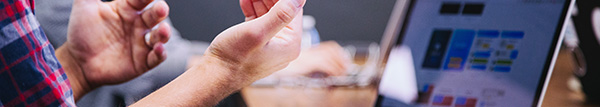 Hands in front of a laptop.