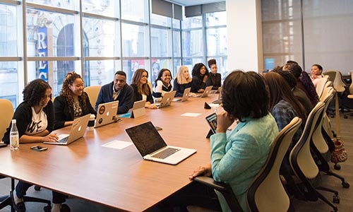 Group of diverse people sitting around a conference table.