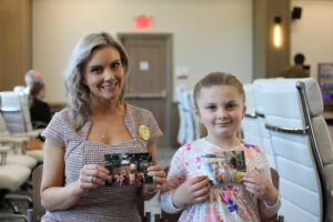 Abby and Eva hold photos from Abby's time at Sumemerscape.