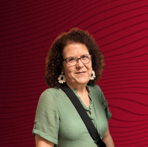 A portrait of Angela Freed, a Drury GO student. Her photo is cutout and is laid on top of an abstract red-black gradient background.