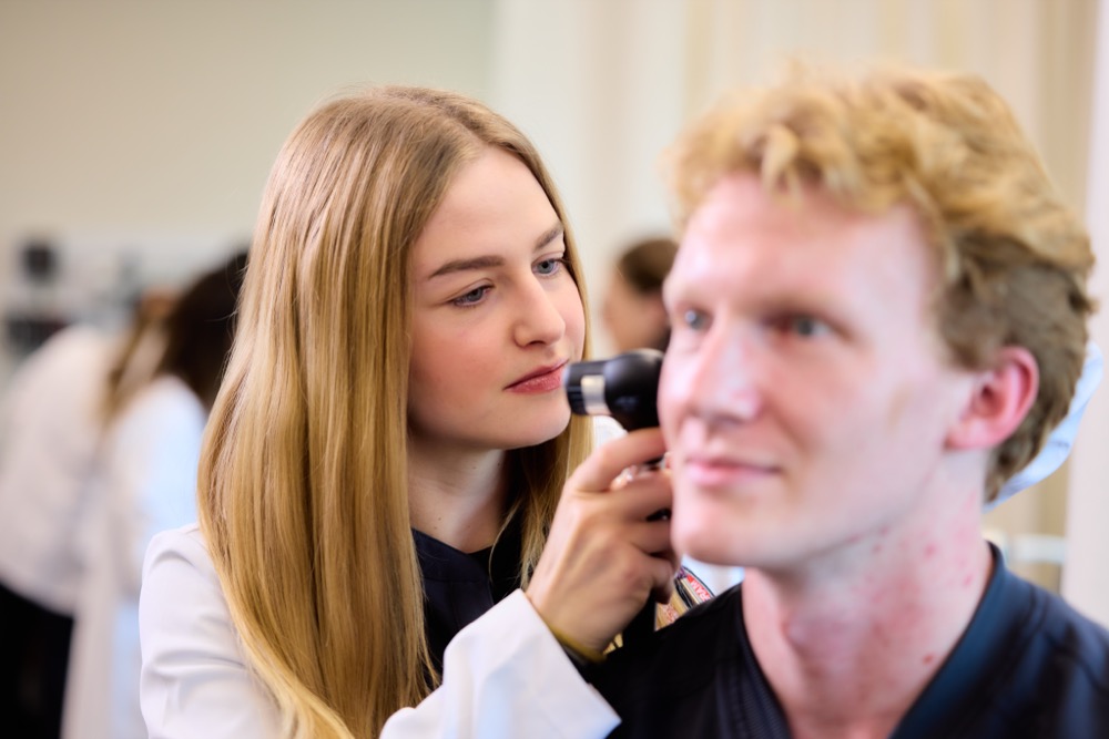 PA Student examining a patient's ear.