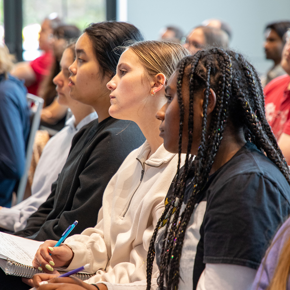a crowd of students look forward, engaged as they listen to the keynote speaker during Fusion Day 2026.